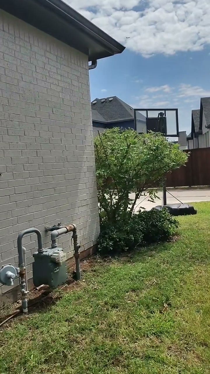 Side of a white brick home with the driveway and garage apron washed by Curb Appeal